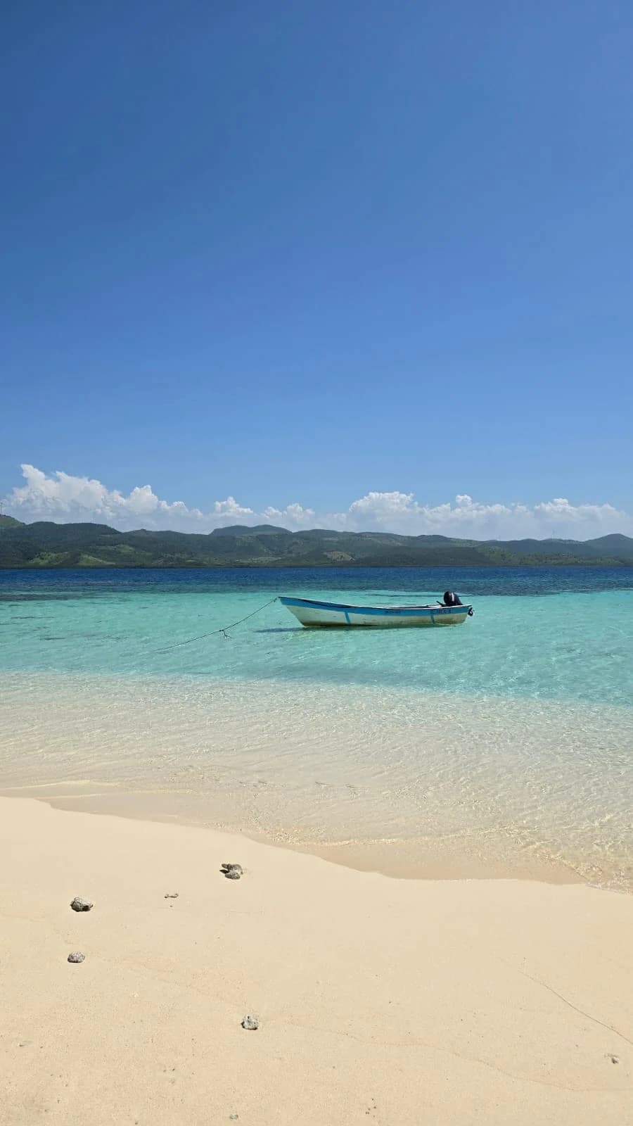 Petit bateau sur un banc de sable à l’eau turquoise